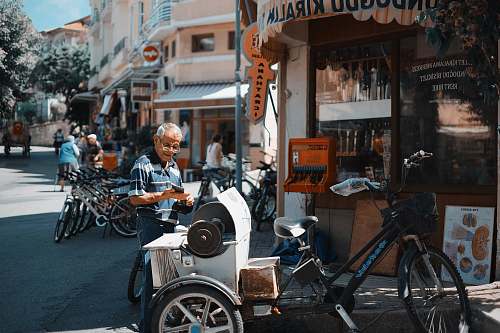 bike man standing behind the trile bicycle