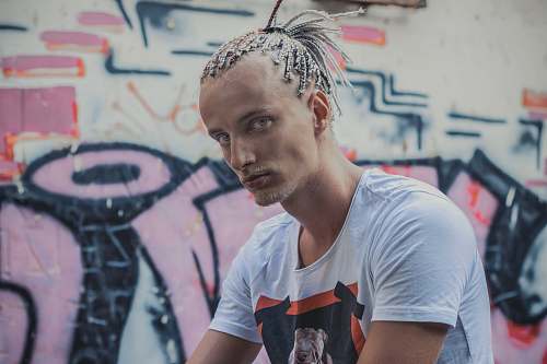 person man standing beside grafitti wall during daytime human