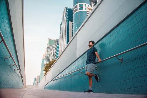 human man standing near blue wall during dayutime person
