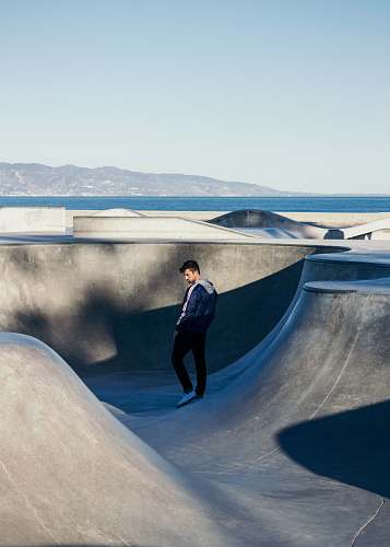 person man standing on bicycle ram under blue sky human