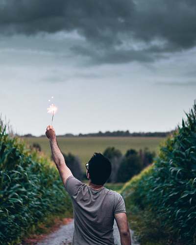 person man standing on pathway holding sparkler human