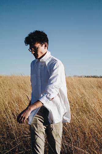 human man walking on brown grass during blue sky person