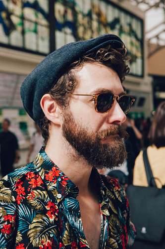 human man wearing multicolored floral shirt and black framed black lens sunglasses person