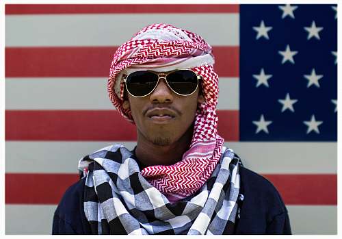 human man wearing sunglasses in front of American flag person