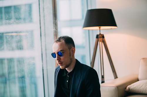 human man wearing sunglasses near table lamp photo person