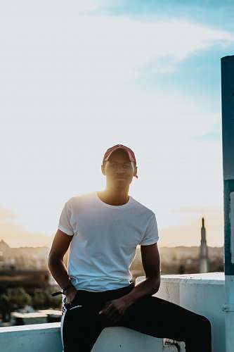 human men's white crew-neck shirt while sitting on white corner person
