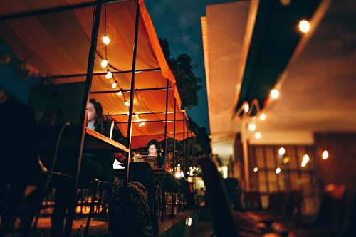 human people sitting on chair outside the restaurant during nighttime person