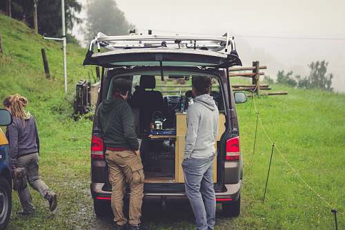 person people standing at the back on an open vehicle human