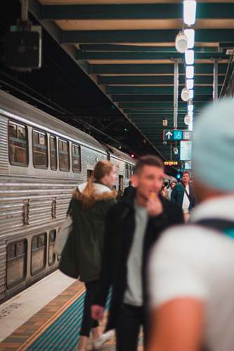 human people standing on train station near train during nighttime person
