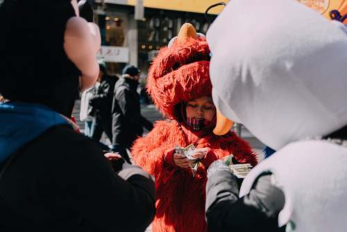 human person counting money in Elmo costume person