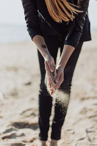 human person holding brown sand during daytime person