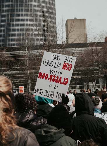 person person holding white signage crowd