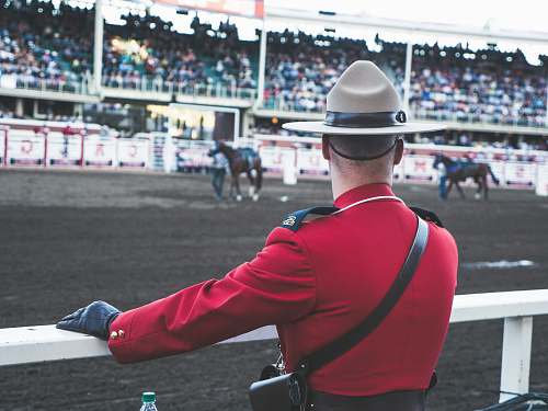 human person in red coat watching horse racing person