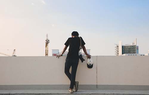 human person leaning against white wall person