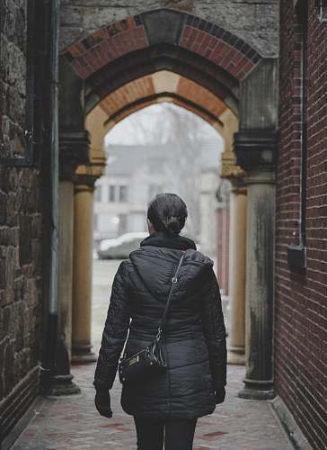 human person standing on alleyway during daytime person