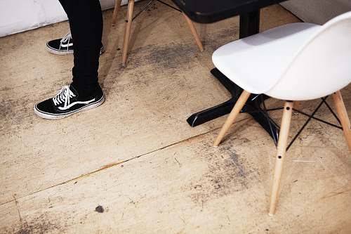person person standing on brown floor near table and chair human