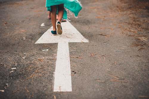 person person walking on arrow street sign road