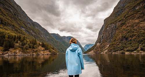 person person wearing blue hooded jacket facing mountain human