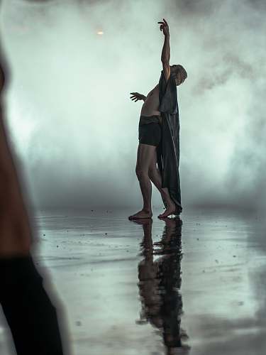 human person wearing robes pointing upward person