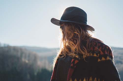 human photo of person with blonde hair wearing hat staring at horizon hat
