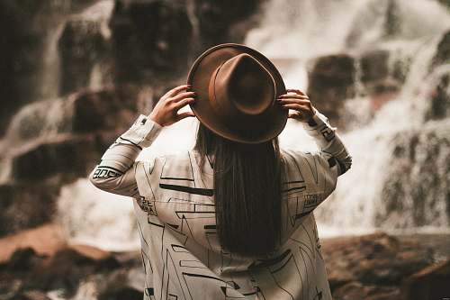 person selective focus photography of woman holding brown fedora hat at daytime human