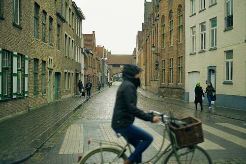 human selective photography of people walking on sidewalks at side of buildings view from person riding city bicycle person