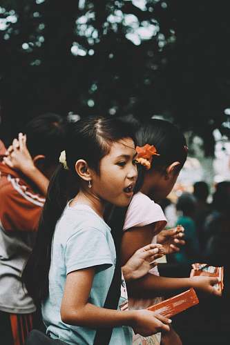 human several children eating snack under shade of tree person