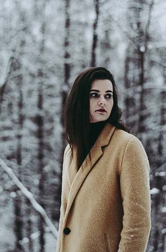 human shallow focus photography of woman standing near treest person