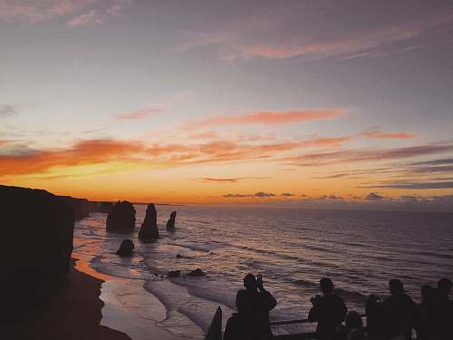 person silhouette of people standing near 12 Apostles landmark in Australia human
