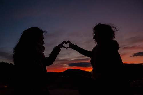 human silhouette of persons doing heart hand person