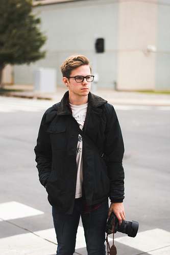 human standing man holding DSLR camera wearing eyeglasses and jacket person