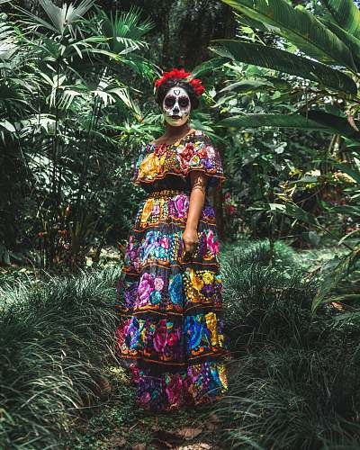 person standing woman surrounded by green plants and trees during daytime clown