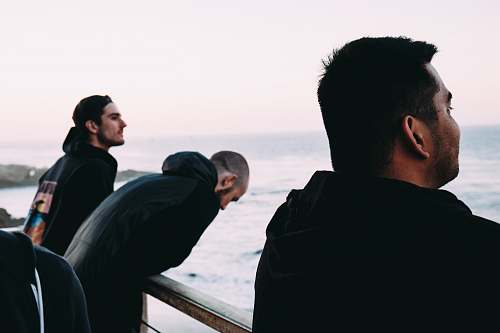 person three men near rail near sea human