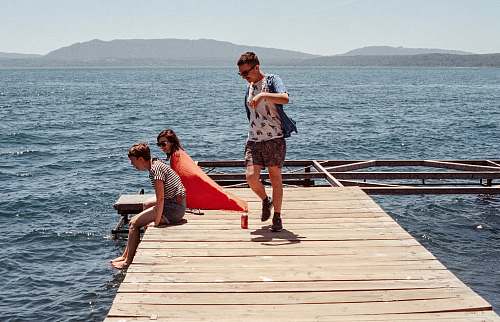 person three person standing on dock pier