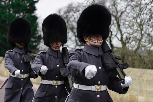 human three Queen's guards carrying sub-machine guns person