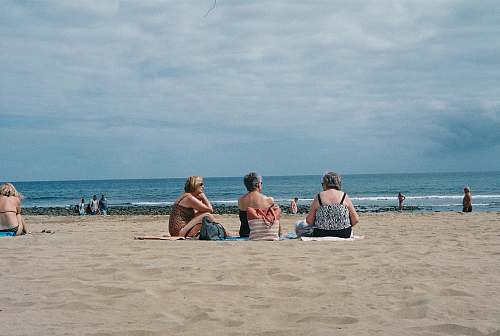 beach three women sitting on beach sea