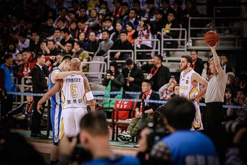 human two basketball players about to hug each other at the court person