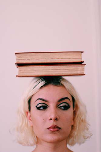 person two books on top of woman's head human