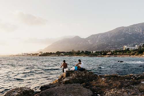 human two men near sea at daytime person
