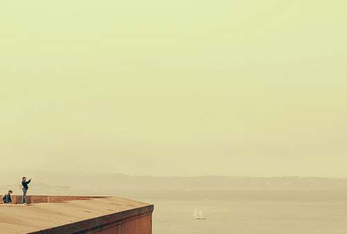 ocean two people standing and sitting on rooftop water