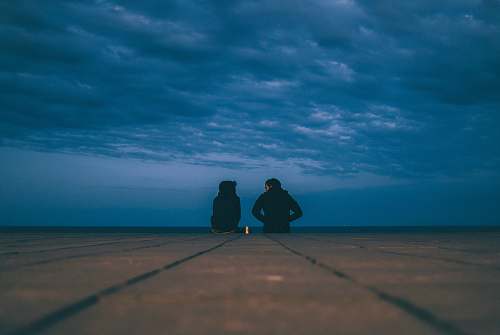 blue two people wearing black jackets sitting on floor water