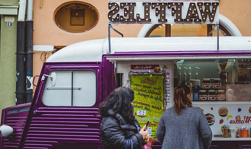 human two women near purple and white waffle van with store at daytime person
