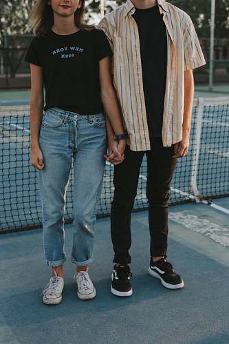 human woman and man standing side by side while holding hands in tennis court person