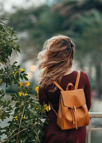 human woman carrying brown leather backpack person