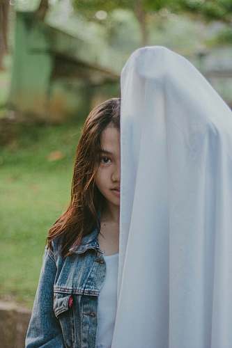 human woman covered half of her face with cloth person