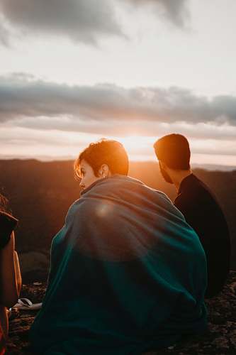 human woman covering green textile near man sitting during sunrise person