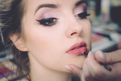 beauty woman getting lips applied with lipstick makeup