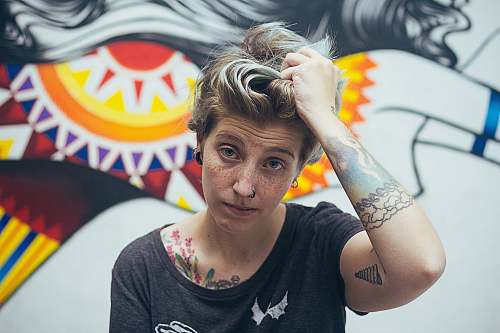 human woman holding her hair near graphic wall person