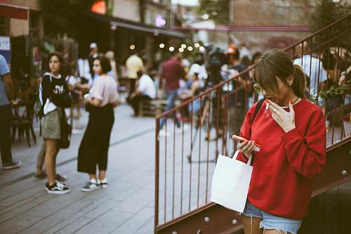 human woman holding her smartphone outdoor during daytime person