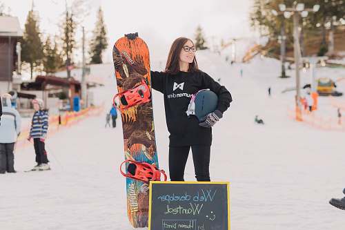 human woman holding orange and brown surfboard person